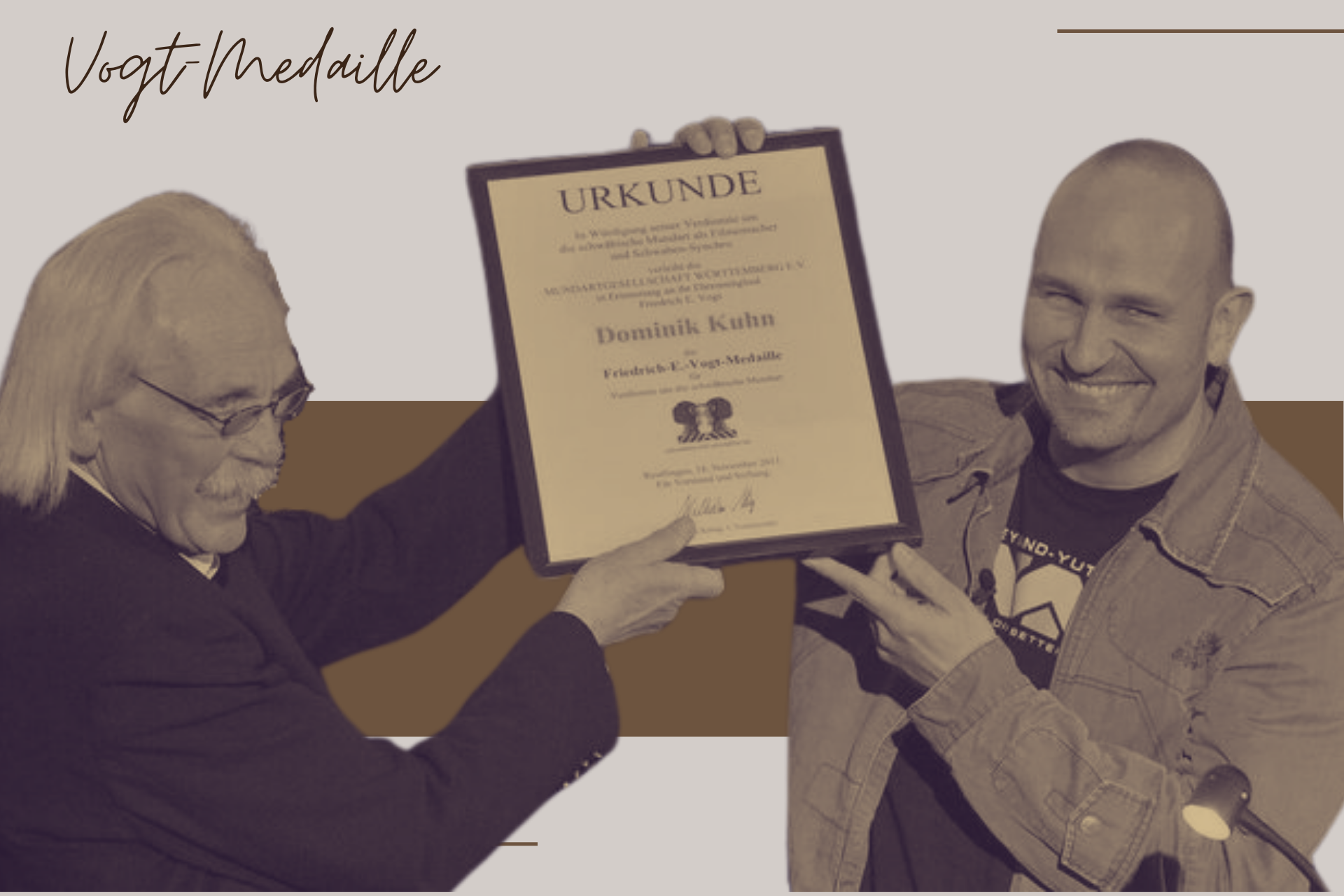 Wilhelm König überreicht Dominik Kuhn alias Dodokay die Urkunde zur Vogt-Medaille